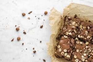 Top view of freshly baked chocolate hazelnut brownies on parchment paper.